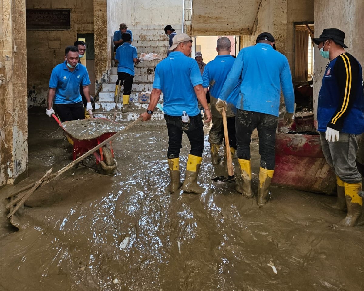 Relawan Aparatur Sipil Negara (ASN) Dinas Kesehatan (Dinkes) Aceh sedang bergotong royong membersihkan genangan lumpur yang masih memenuhi seluruh ruangan Kantor Dinas Kesehatan Kabupaten Aceh Tamiang. (Foto direkam : Senin, 29/12/2025).