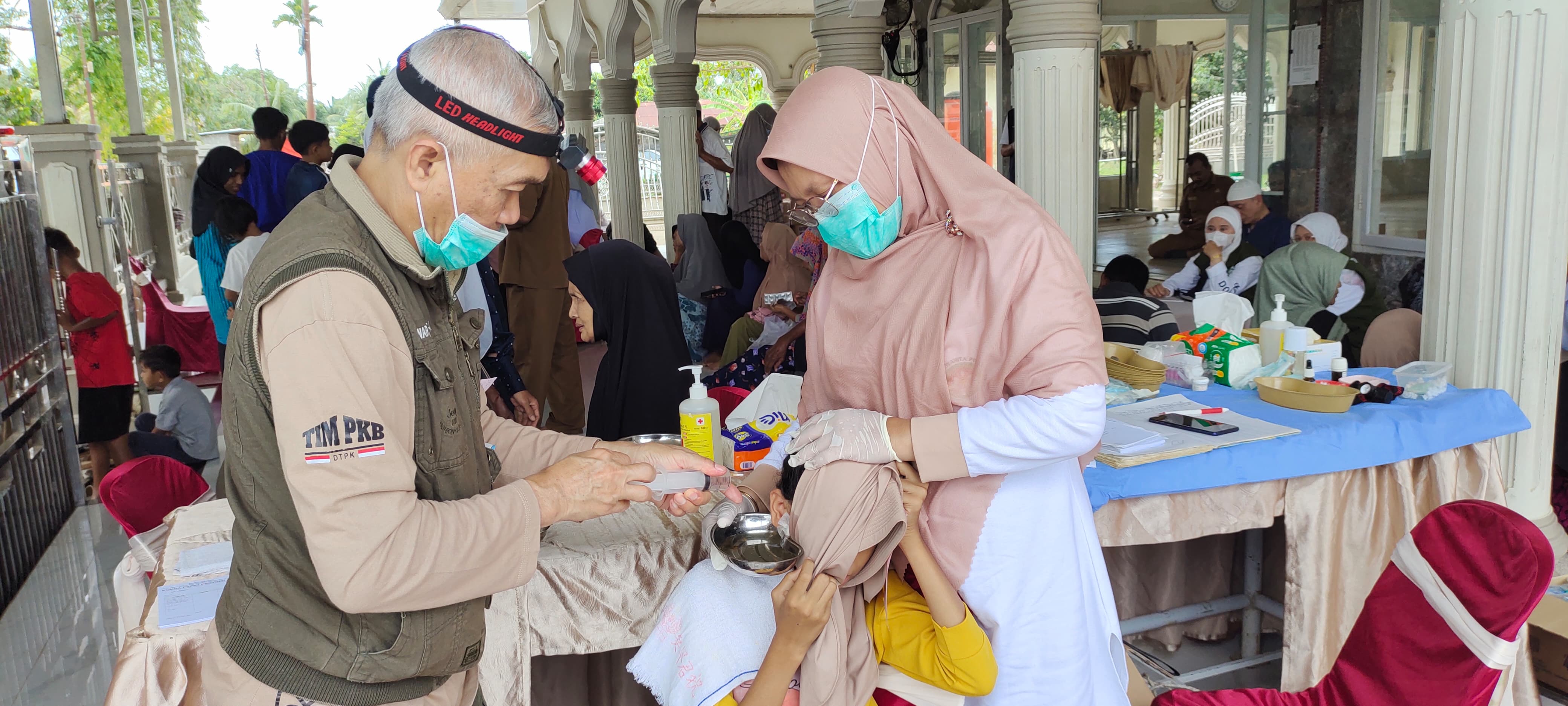 Dokter Spesialis THT sedang membersihkan telinga salah satu anak di Desa Blang Peuria, Kecamatan Samudera, Kabupaten Aceh Utara, Senin (2/3/2026).