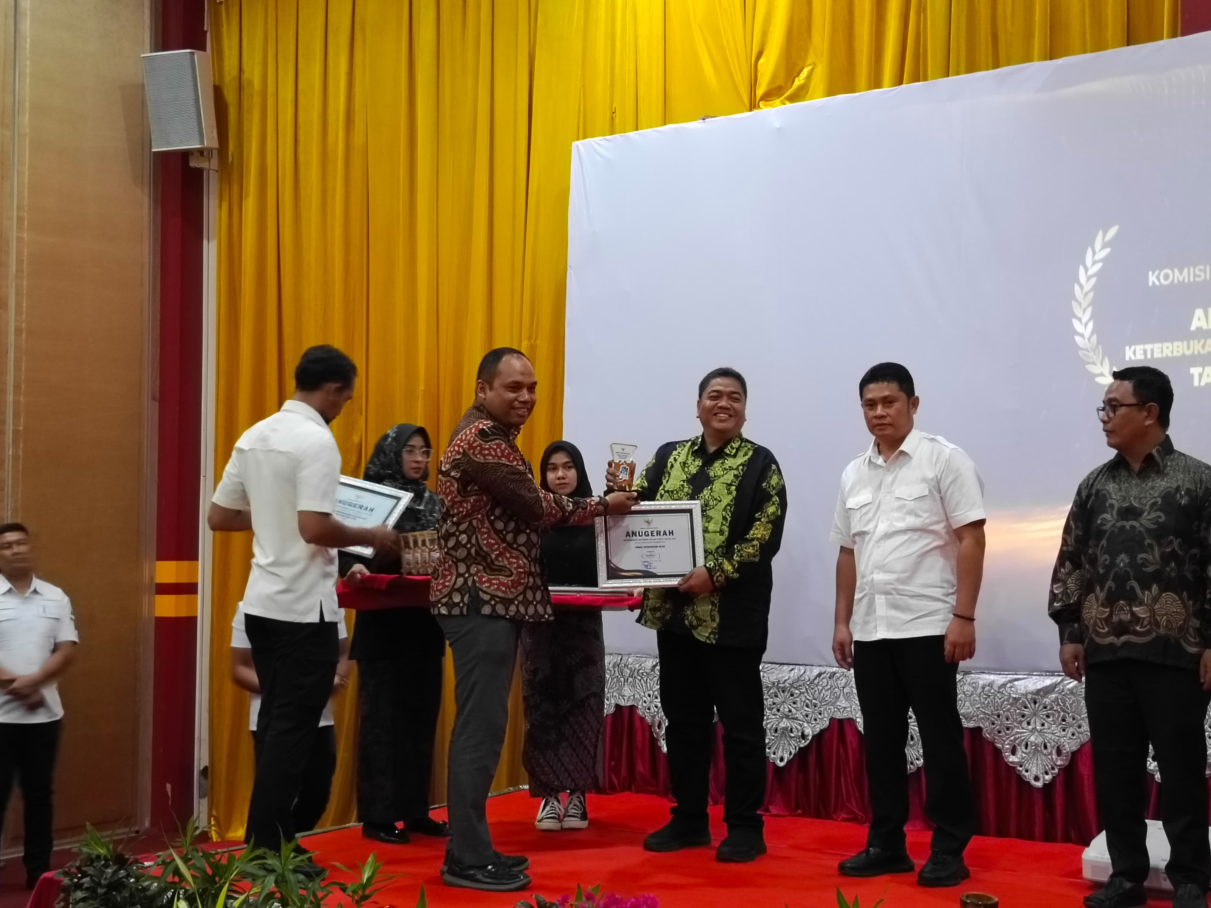 Kadinkes Aceh, dr. Munawar,Sp.OG (K) menerima penghargaan Keterbukaan Informasi Publik kategori Satuan Kerja Perangkat Aceh dengan Kualifikasi Informatif yang diserahkan oleh Ketua Komisi Informasi Aceh, Arma Fauzi, pada Rabu (6/12/2023) di Amel Convention Hall Banda Aceh.