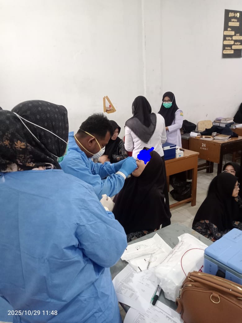 Petugas medis sedang mengambil spesimen dengan cara swap tenggorokan kontak erat terduga Difteri di lingkungan Pesantren Ruhul Islam Aneuk Bangsa pada Rabu (29/10/2025). 